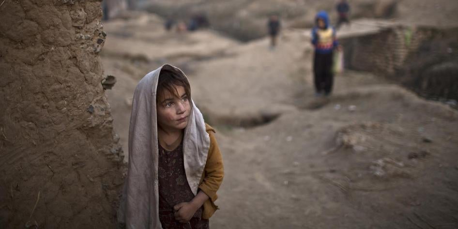 An Afghan girl stands by the doorway of her family's mud house in a poor neighborhood on the outskirts of Islamabad, Pakistan. December 2014.  © 2014 Associated Press