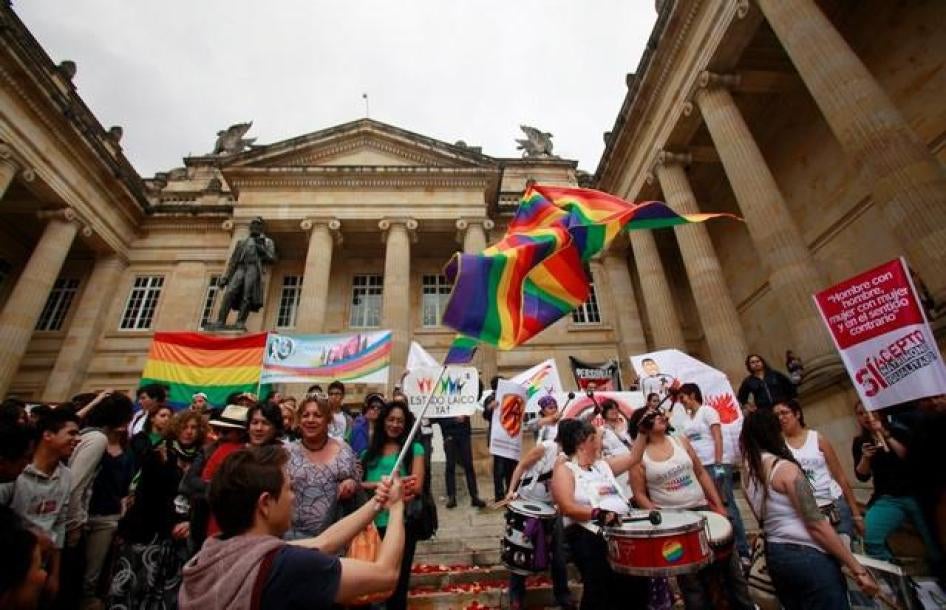Manifestantes ondean banderas arcoíris para reclamar derechos de personas LGBT fuera del edificio del Congreso en Bogotá.