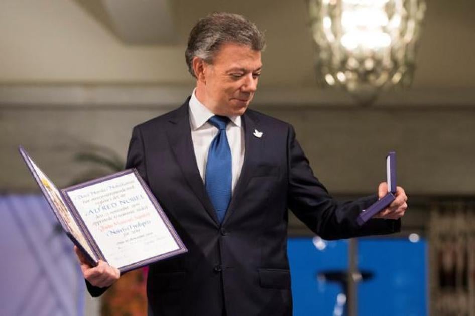 Nobel Peace Prize laureate Colombian President Juan Manuel Santos poses with the medal and diploma during the Peace Prize awarding ceremony at the City Hall in Oslo, Norway on December 10, 2016.