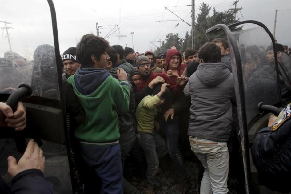 Dans le camp surpeuplé d’Idomeni dans le nord de la Grèce, des policiers anti-émeute tentent de repousser une foule de migrants et réfugiés qui cherchent à traverser la frontière avec la Macédoine, le 29 février 2016.