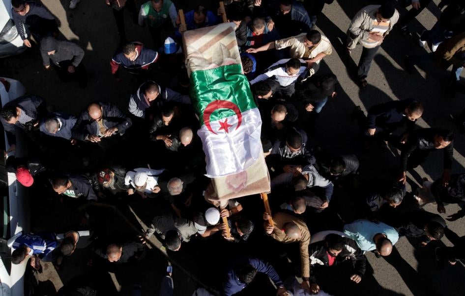 Des proches du journaliste Mohamed Tamalt, détenteur de la double nationalité algérienne et britannique, transportent son cercueil le 12 décembre 2016 à Alger, au lendemain de son décès survenu à l’issue d’une grève de la faim entamée après sa condamnatio