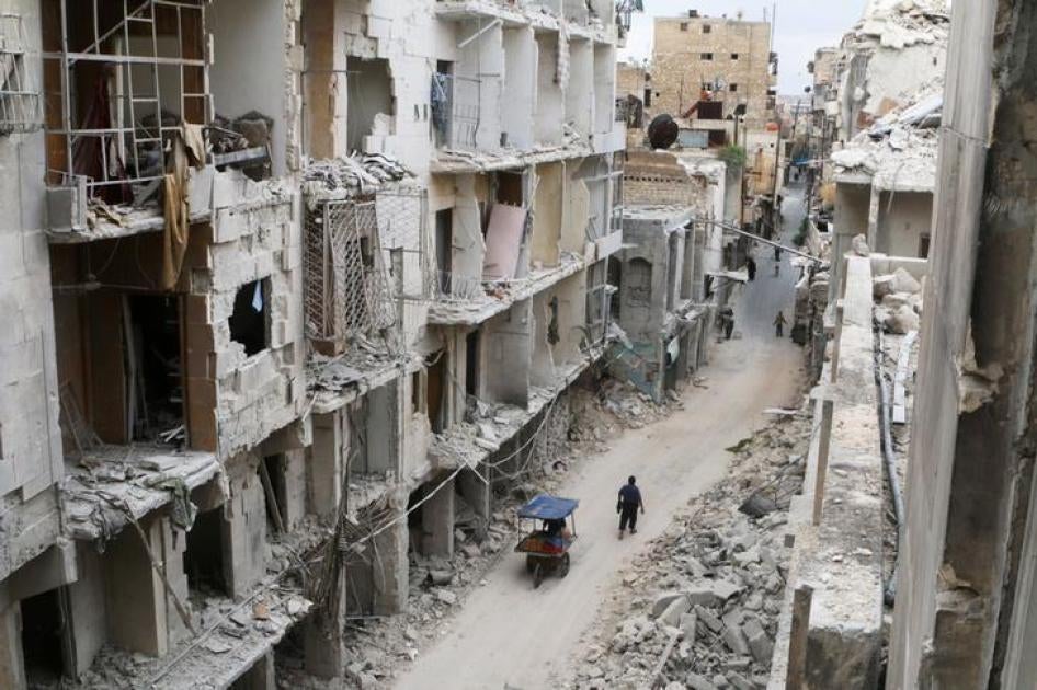 سكان يمشون قرب أبنية مدمرة في منطقة سيطرة المعارضة في حلب القديمة، سوريا في 5 مايو/أيار 2016. 