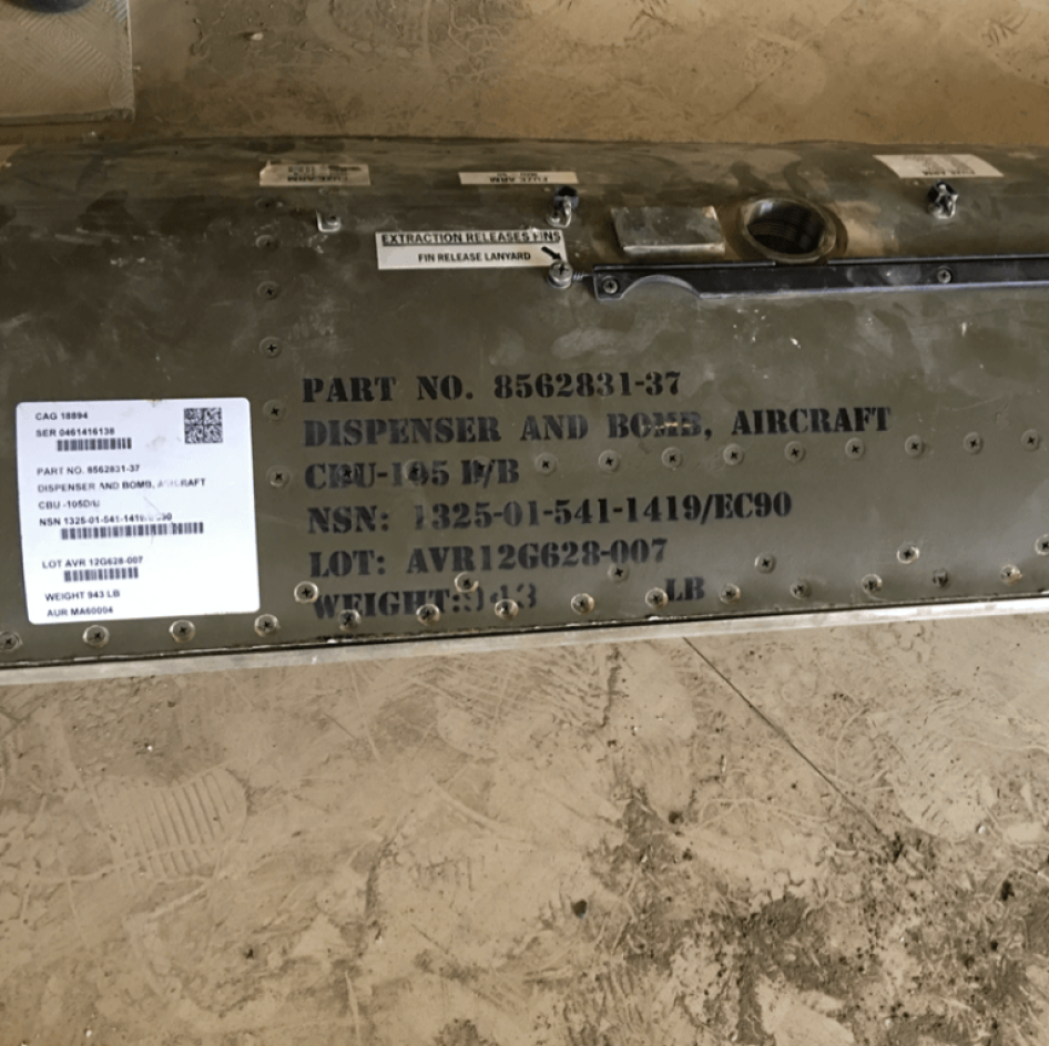 The casing from a CBU-105 Sensor Fuzed Weapon used in the attack near the quarry of the Amran Cement Factory on February 15, 2016, found by factory staff on the road up to the quarry.  The markings show that the weapon was produced in July 2012 by the Tex