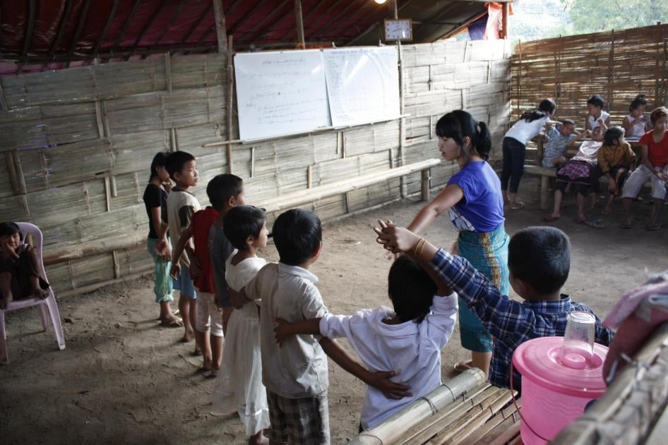 Children learn a traditional Kachin dance at a makeshift school staffed by volunteer teachers in a displaced persons camp outside Laiza, Kachin State. 