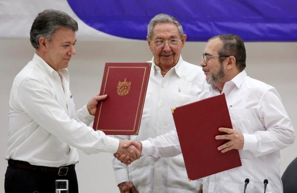Kubas Präsident Raul Castro (M), Kolumbiens Präsident Juan Manuel Santos (L) und Farc Rebellen Führer Rodrigo Londono, besser bekannt als der Guerillero Timochenko, reagieren nach dem Unterzeichnen des Waffenstillstands zwischen der kolumbianischen Regier