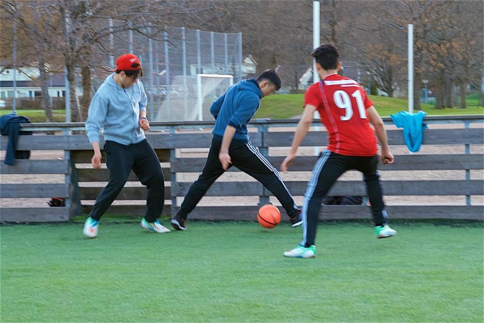 Afghanska pojkar spelar fotboll utanför ett gruppboende i Göteborg. 