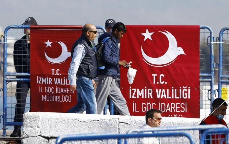 Officials in Dikili, Turkey escort deportees off the boat from Greece on April 4, 2016.