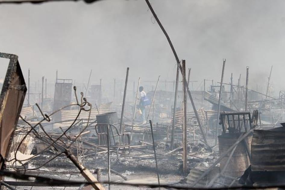 People walk among rubble in an United Nations base in the northeastern town of Malakal on February 18, 2016.