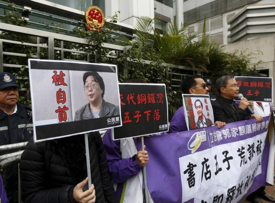  香港泛民主派公民党成员带著桂敏海（左）和李波的照片，在中联办门外抗议，2016年1月19日。 