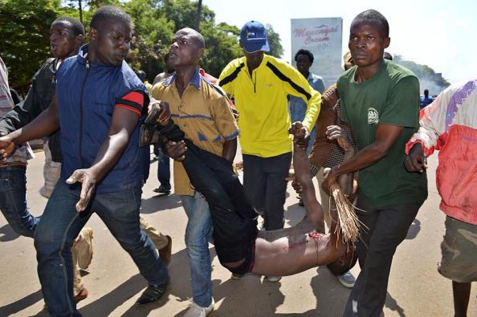 Protestors carry an injured man after he was shot by police in the western city of Kisumu, Kenya, during demonstrations by opposition supporters on June 6, 2016. 