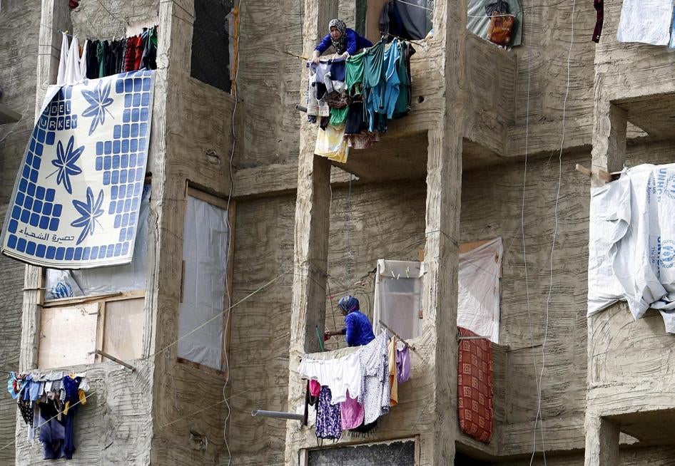 Des refugiées syriennes suspendent leur linge aux balcons d’un centre de réfugiés à Sidon, dans le sud du Liban, le 17 avril 2015.