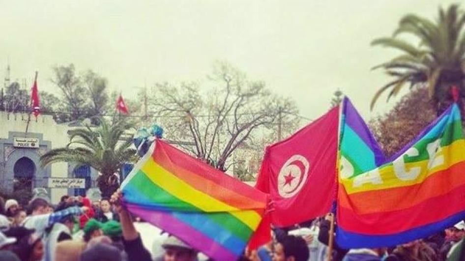 متظاهرون يرفعون أعلاما تونسية وعلما بألوان قوس قزح أثناء مسيرة ضدّ الإرهاب على هامش المنتدى الاجتماعي العالمي – تونس، مارس 2015.