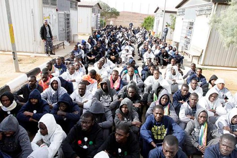 مهاجرون محتجزون، بعد أن حاولوا الوصول إلى أوروبا، يجلسون على الأرض في موقع احتجاز في غريان، غرب ليبيا، 1 ديسمبر/كانون الأول 2016.