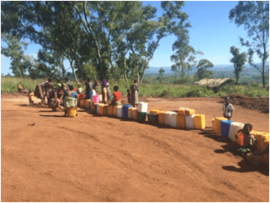Mulheres e raparigas num dos dois únicos poços de furo no campo sobrelotado de Kapise, no Malawi, que serve atualmente mais de 6000 pessoas. 