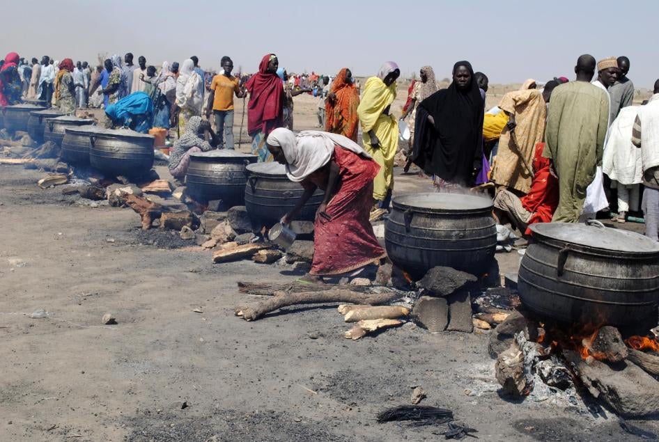 Women cook in pots heated up with firewood at an Internally Displaced Persons (IDP) camp at Dikwa in Borno State, north-eastern Nigeria, on February 2, 2016.