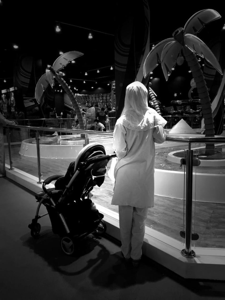 Une travailleuse domestique migrante surveille un enfant jouant au Magic Planet du City Centre Muscat, un centre commercial d'Oman.
