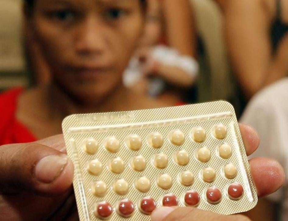 An NGO health worker holds contraceptive pills during a family planning session with housewives availing free pills in Tondo, Manila August 6, 2012. 