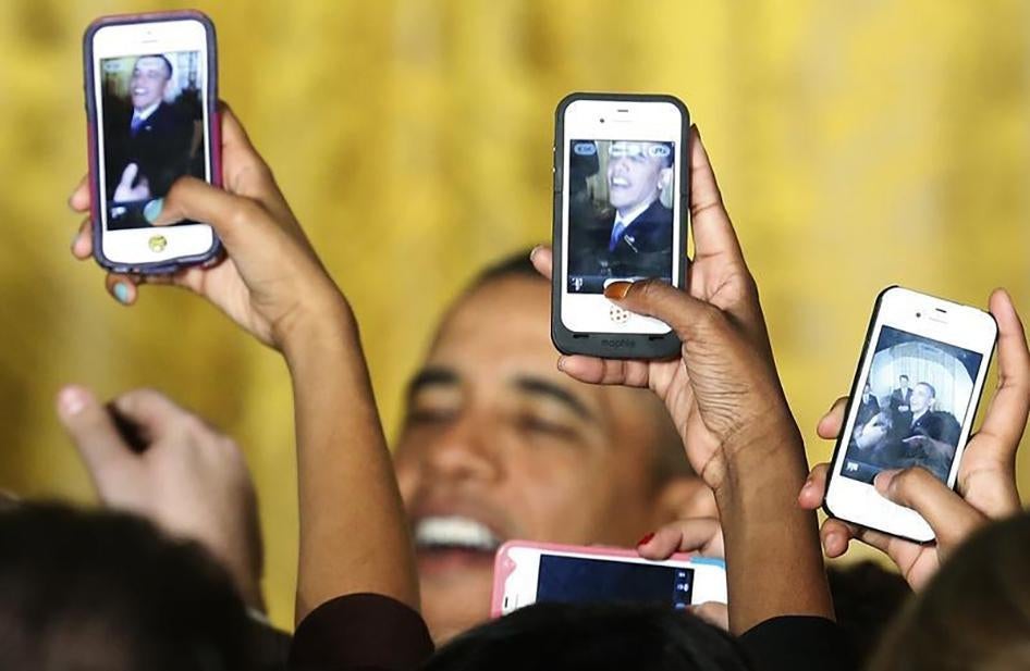Audeince members hold up Apple iPhones to photograph President Barack Obama after he spoke at a Women's History Month reception.