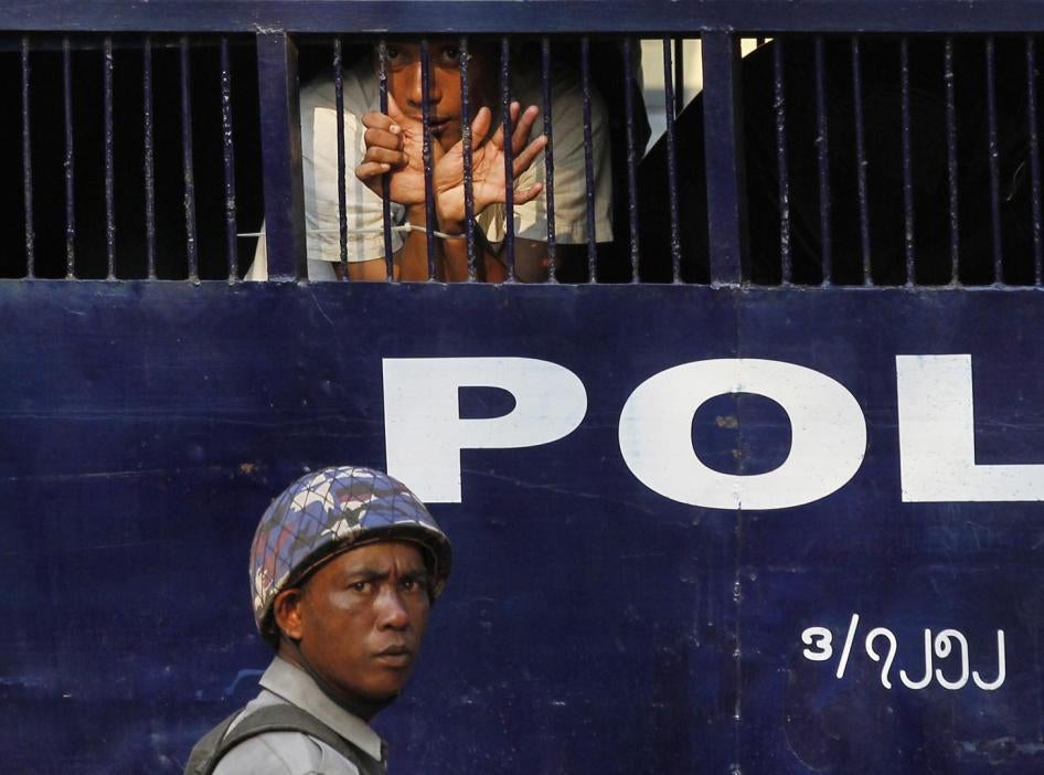 Un étudiant arrêté suite à une manifestation dans la ville de Letpadan, en Birmanie, agenouillé derrière les barreaux d'un fourgon de police, le 11 mars 2015. 