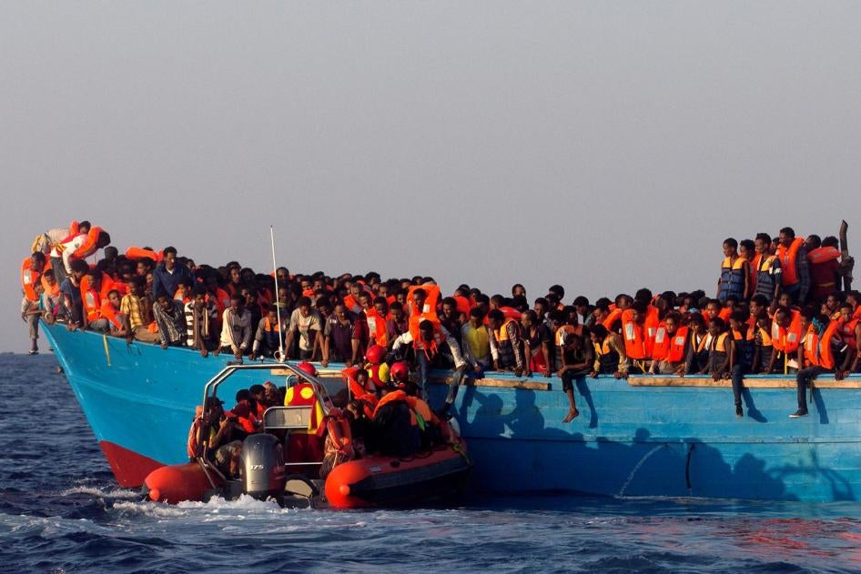 A rescue boat of the Spanish NGO Proactiva approaches an overcrowded wooden vessel off the Libyan coast, August 29, 2016.