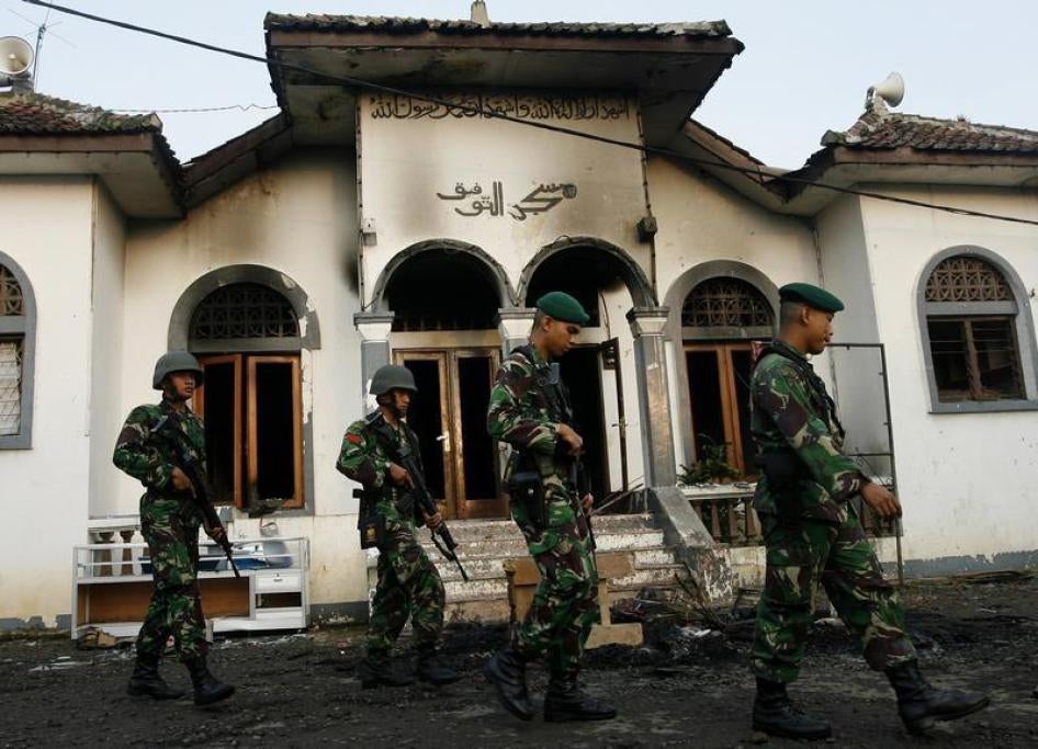Soldiers walk past a burnt mosque owned by followers of the minority Islamic sect, Ahmadiyah, in Ciampea, a village in Indonesia's West Java province October 2, 2010.