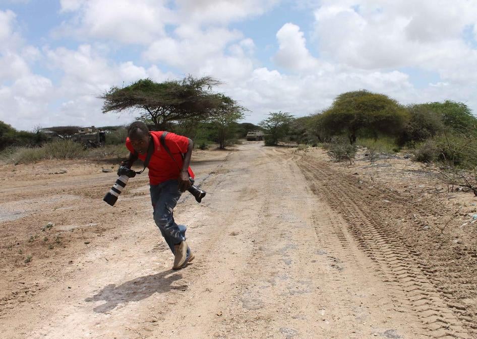 Somali photojournalist runs for cover while reporting on fighting between the Somali government and African Union forces against the Islamist armed group Al-Shabab in the Lower Shabelle region of Somalia, April 2012. 