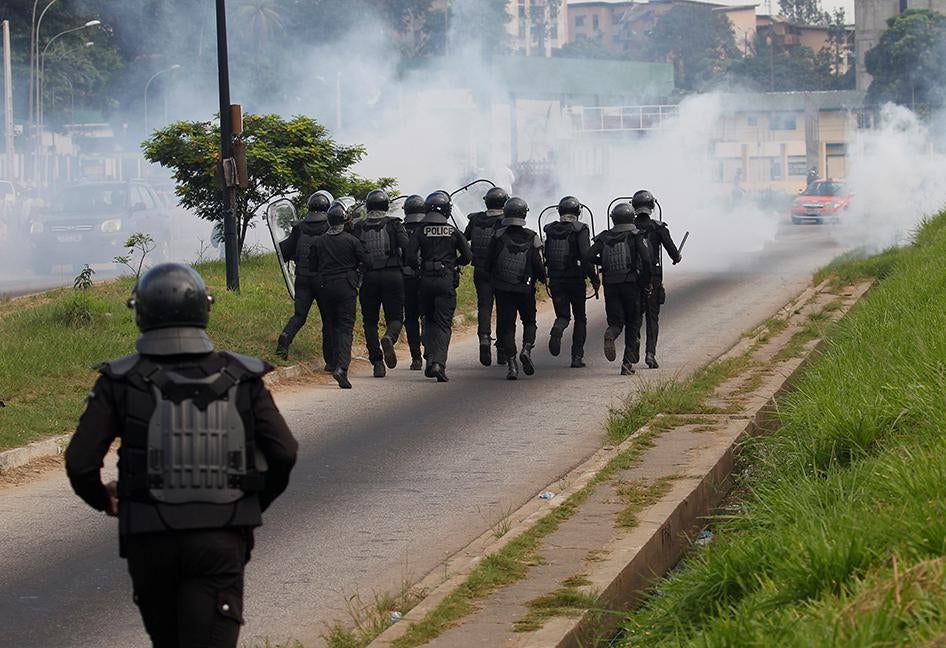 Des policiers anti-émeute ivoiriens recourent à du gaz lacrymogène pour disperser une marche de partisans de l’opposition tenue le 20 octobre 2016 à Abidjan, Côte d’Ivoire, afin de protester contre le projet de nouvelle constitution. 