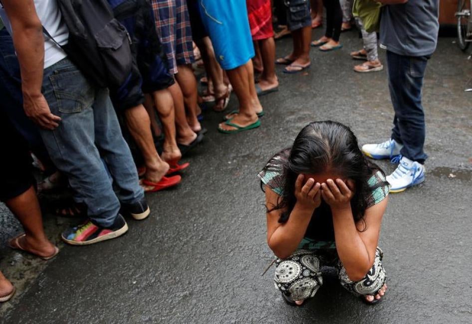 A family friend weeps after Nora Acielo, 47, was gunned down by unidentified men while escorting her two children to school in Manila, Philippines December 8, 2016.