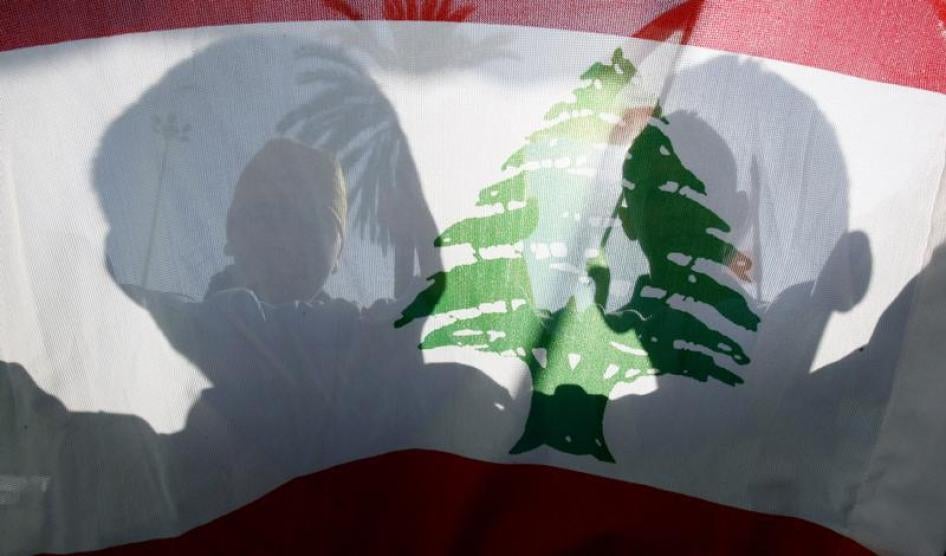 Un drapeau national libanais, tenu par des manifestants dont on aperçoit les silhouettes, lors d'un rassemblement à Beyrouth le 11 décembre 2006.