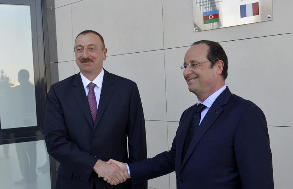 Azerbaijan's President Ilham Aliyev (L) shakes hands with his French counterpart Francois Hollande as they visit a local French school under construction in Baku, May 11, 2014.