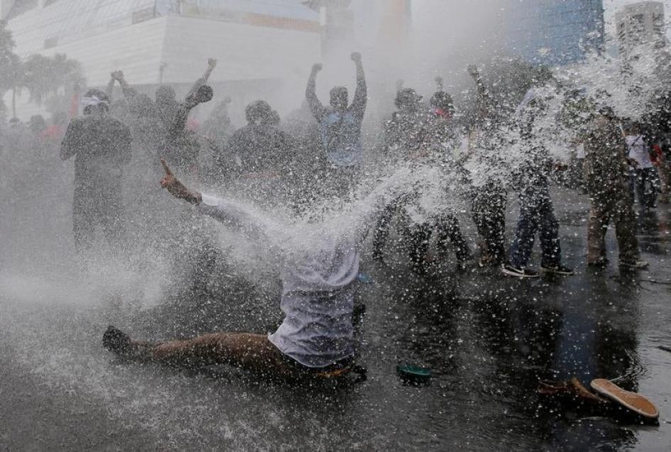 Protesters react as police spray water canon to disperse them during a rally calling for their right to self-determination in the Indonesian controlled part of Papua, in Jakarta, Indonesia, December 1, 2016.