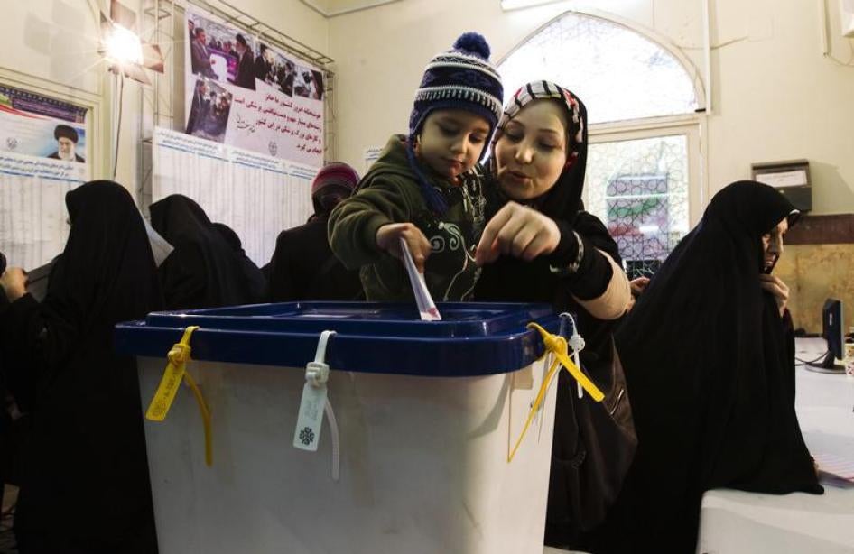 A woman lets her child cast her ballot during the parliamentary election, at a mosque in southern Tehran March 2, 2012.