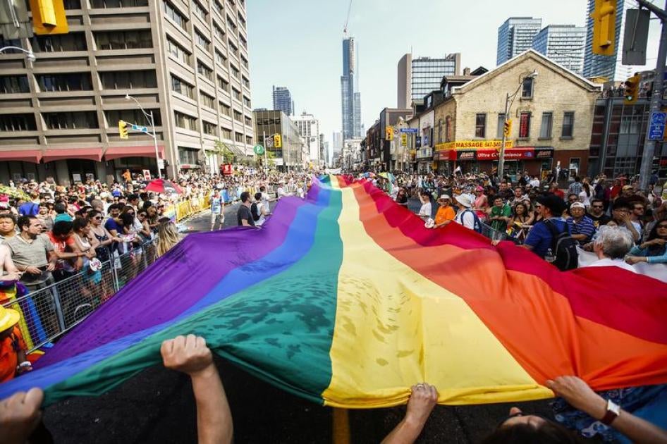 Revellers hold a giant pride flag during the "WorldPride" gay pride Parade in Toronto, June 29, 2014.