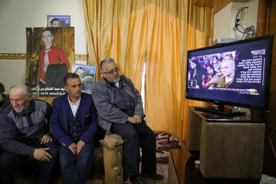 والد الفلسطيني عبد الفتاح الشريف وأقاربه يشاهدون بث جلسة الحكم على الجندي الإسرائيلي إلور أزاريا في الخليل، الضفة الغربية.