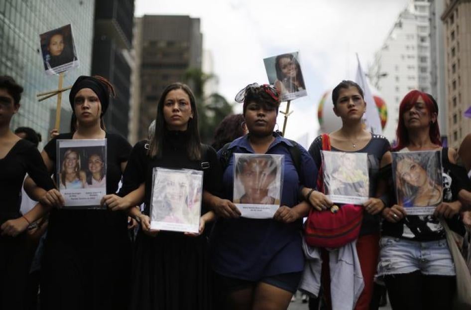 Durante uma marcha no Dia Internacional da Mulher em São Paulo, 8 de março de 2014, mulheres seguram fotos de vítimas que morreram de violência doméstica.