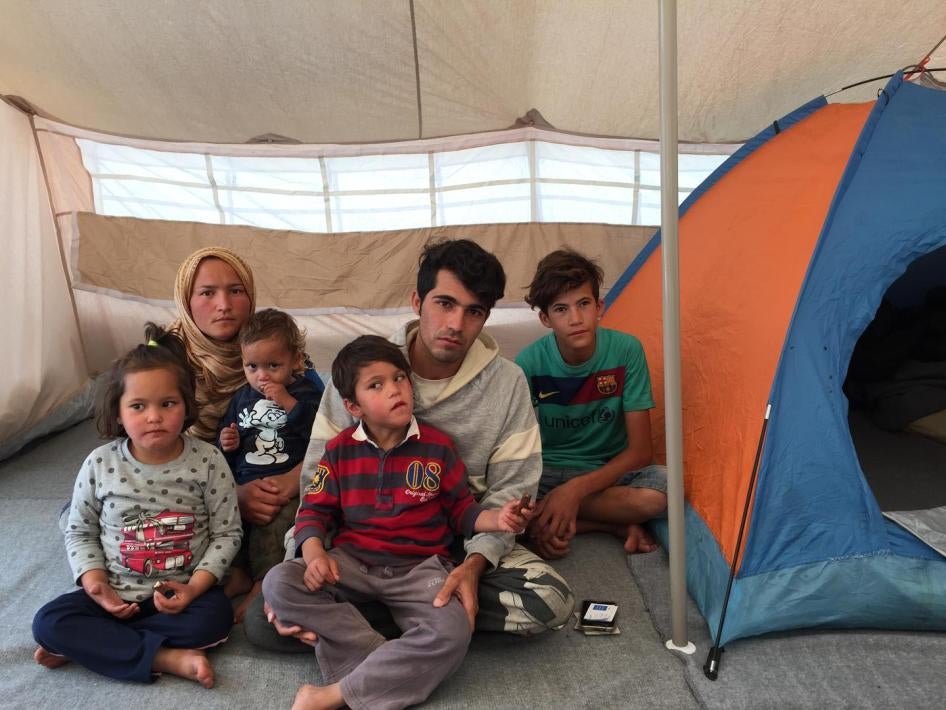Yasami et Ali Habibi, deux réfugiés afghans photographiés en octobre 2016 avec leurs trois jeunes enfants et le frère d'Ali, âgé de 14 ans, dans une tente du camp d'Eiliniko à Athènes, en Grèce. Leur fils de 6 ans, assis sur les genoux d’Ali, a un trouble