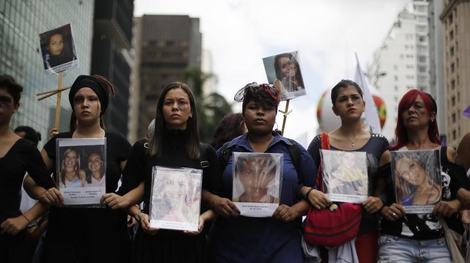 Marchers hold pictures of women killed violently to mark International Women's Day in São Paulo on March 8, 2014.