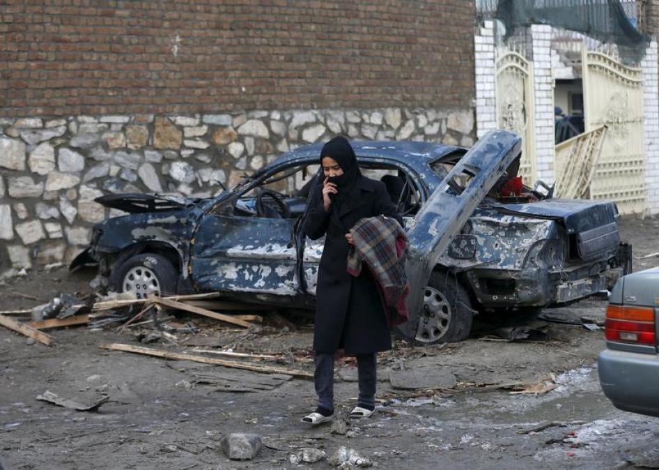 An Afghan woman walks past a damaged car after a suicide attack on French restaurant "Le Jardin" in Kabul, Afghanistan January 2, 2016. 