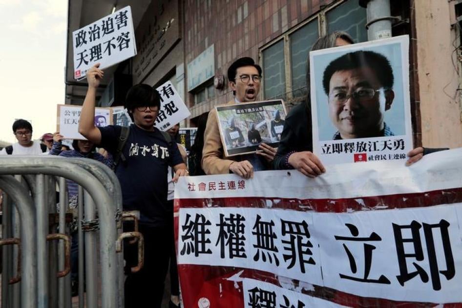 民主派示威人士在中联办门外举起被吊照律师江天勇的照片，要求将他释放，中国香港，2016年12月23日。