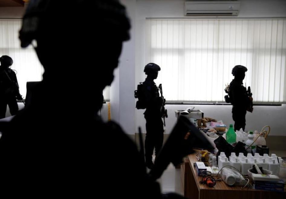 Counterterrorism police stand guard near evidence confiscated in raids on suspected militants at police headquarters in Jakarta, Indonesia, November 30, 2016.
