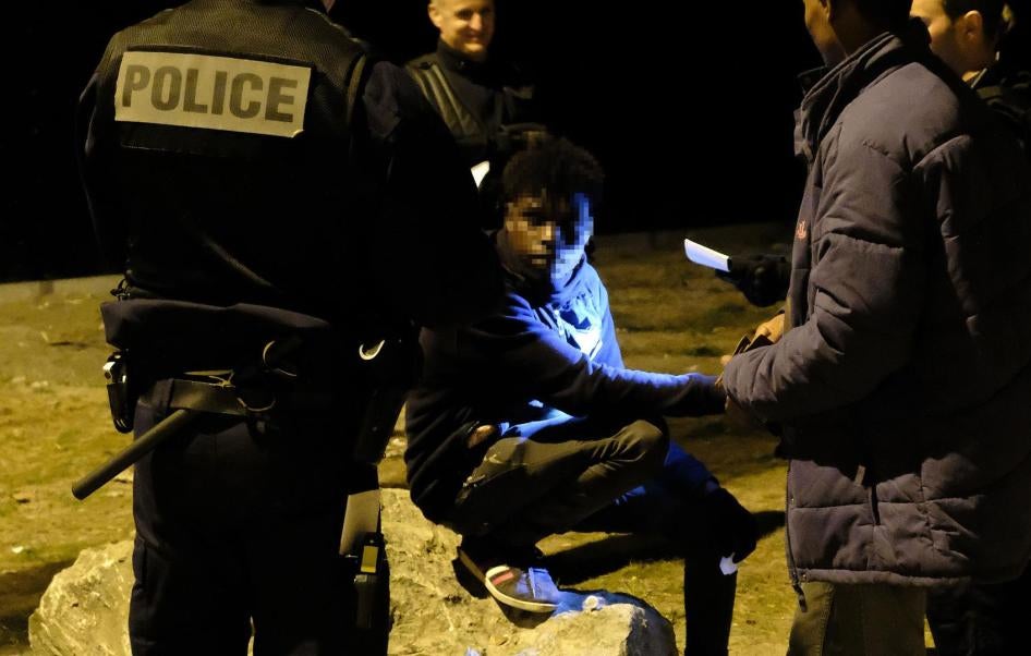 La policía revisa documentos de identidad después de detener la distribución de alimentos, agua y ropa en una zona industrial de Calais poco después de la medianoche del 30 de junio de 2017. 