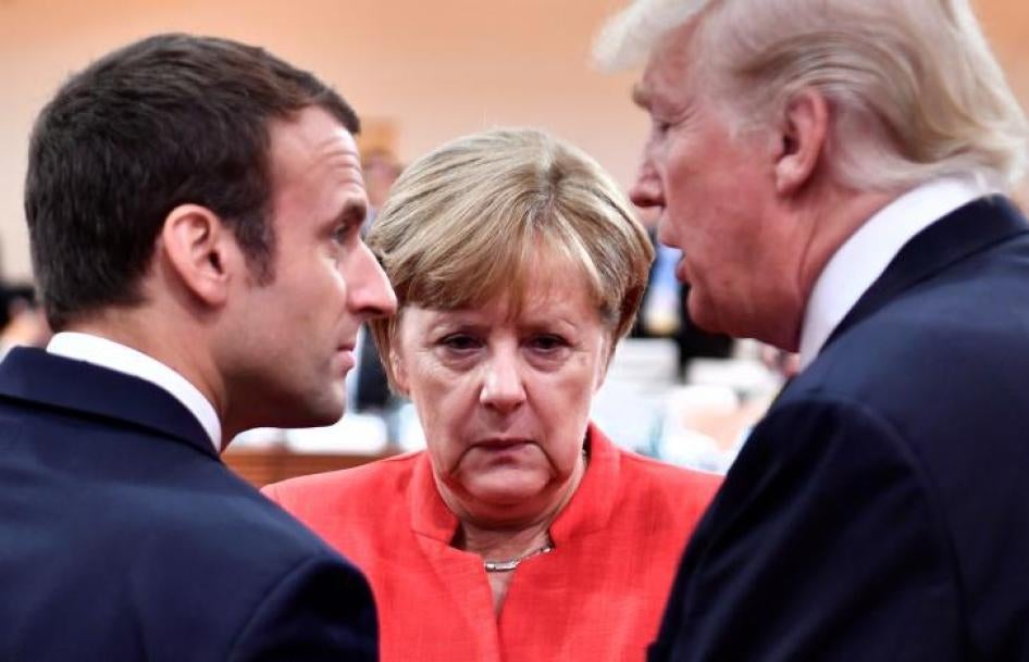 Le Président français Emmanuel Macron, la Chancelière allemande Angela Merkel et le Président américain Donald Trump se concertent au début de la première session de travail de la réunion du G20 à Hambourg, en Allemagne, le 7 juillet 2017. 