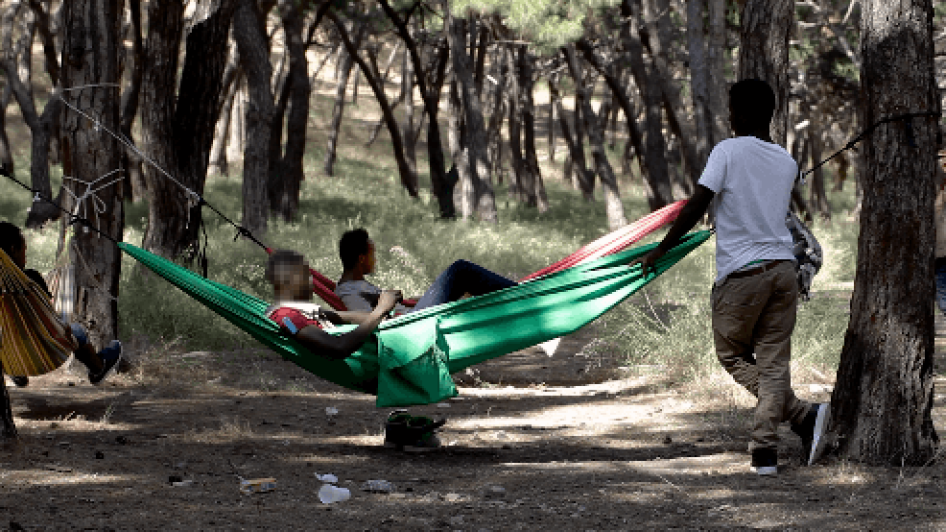 « Amadou », un garçon de 16 ans non accompagné originaire d'Afrique de l'Ouest, près de deux autres jeunes personnes étendues dans des hamacs dans l'île de Lesbos, en Grèce. 28 juin 2017.