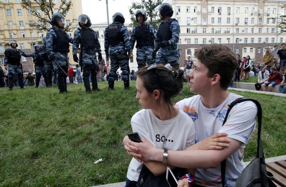 A couple sits in front of riot police standing guard during an anti-corruption protest organised by opposition leader Alexei Navalny, on Tverskaya Street in central Moscow, Russia, June 12, 2017. 