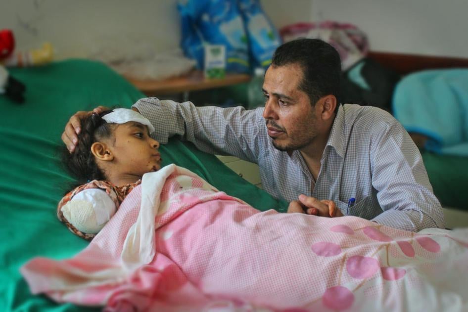 جميل قايد يواسي طفلته ملك (8 أعوام) بعد أن بترت ذراعها. جُرحت ملك خلال إحدى عمليات القصف المدفعي من قبل قوات الحوثي-صالح على حي الضبوعة، تعز، في 23 مايو/أيار 2017. 