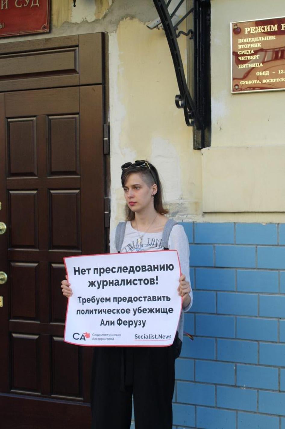 Activist outside Moscow’s Basmanny District court on August 1, 2017 holds a poster declaring “Say no to persecution of journalists! We demand asylum for Ali Feruz.”