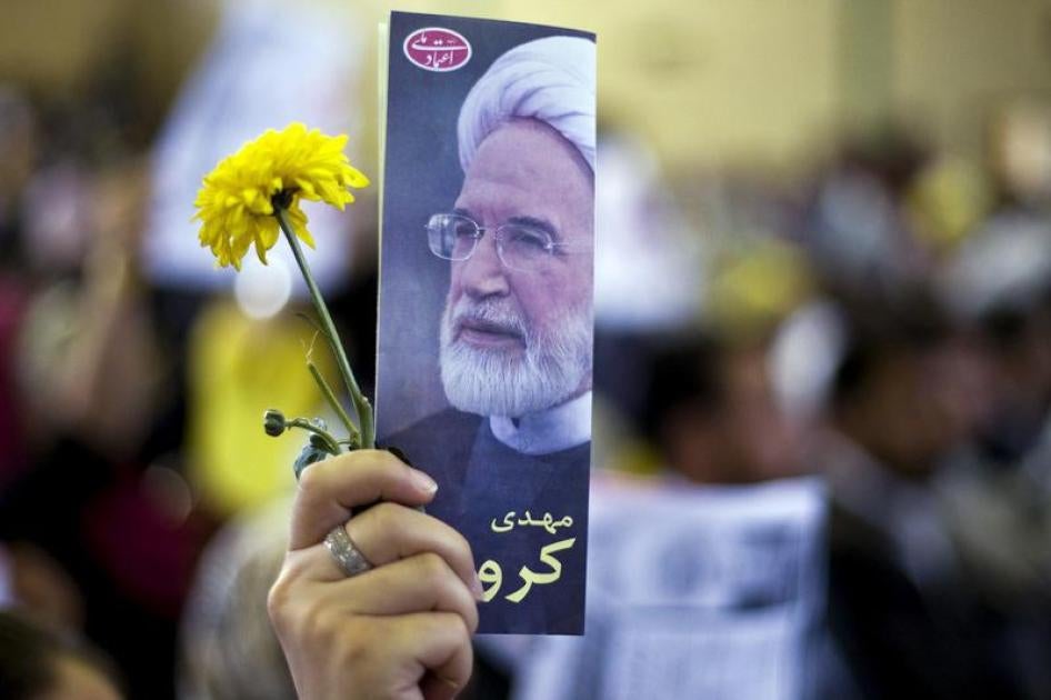 A supporter holds up a picture of presidential candidate Mehdi Karroubi during a rally in Tehran May 29, 2009.