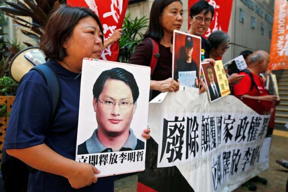 香港民主派人士手持在押台湾人权工作者李明哲（左）及其他维权人士相片表达抗议，中国香港，2017年9月11日。