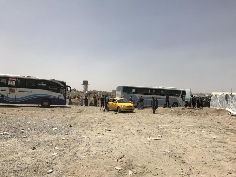 باصات وزارة النقل العراقية تنقل عائلات نازحة إلى حمام العليل في مايو/أيار 2017. في أواخر أغسطس/آب، نقلت السلطات العراقية في باصات 1400 امرأة وطفل أجانب إلى هذا الموقع.