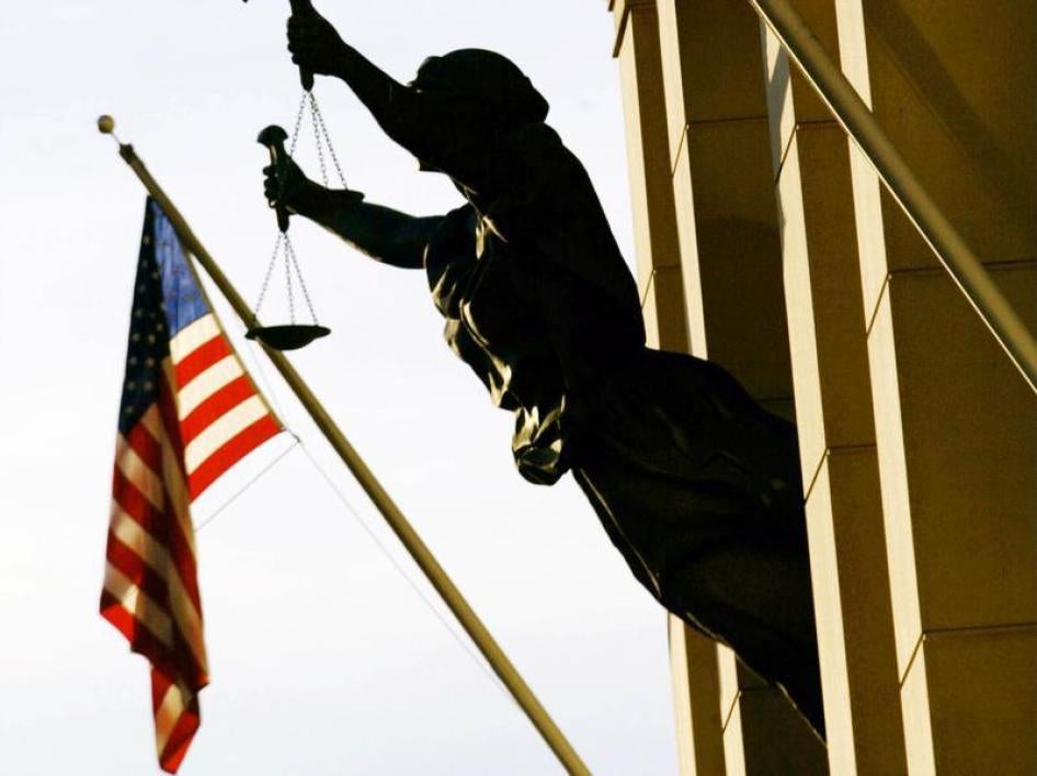 The American flag flies next to a statue of the scales of justice at United States Court House, February 6, 2002.